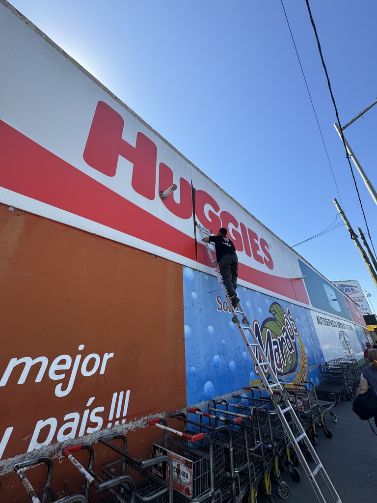 Instalación de cartel publicitario para Huggies en estacionamiento