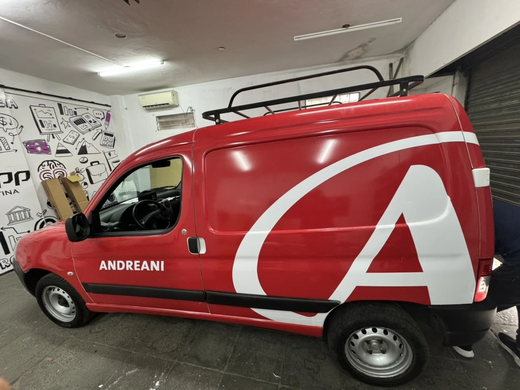 Camioneta roja ploteada con logo de Andreani